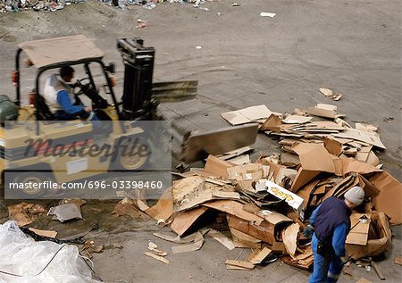 Workers moving large pile of cardboard boxes