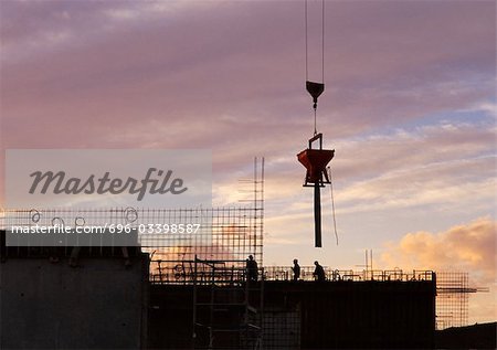 Construction site, silhouette, sky at sunset in background