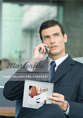 Mann am Telefon sprechen und halten Kalender