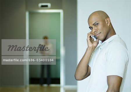 Man phoning, elevator in background