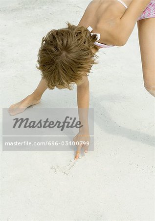 Fille de dessin dans le sable