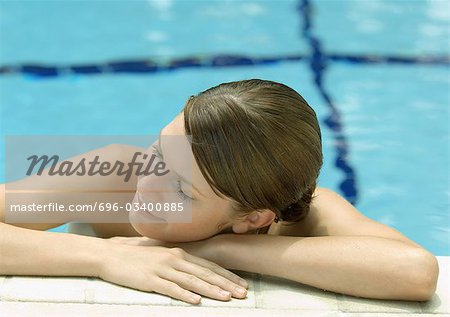 Woman resting head on side of pool