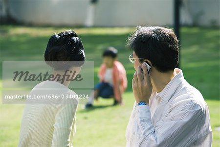 Parents se tournés vers les fils, l'homme à l'aide de téléphone portable