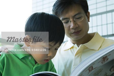 Father and son reading book