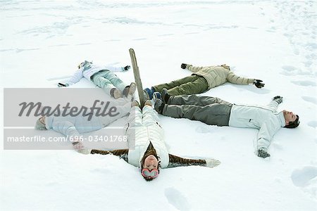 Jeunes amis gisant sur le sol en cercle autour de poteau en bois