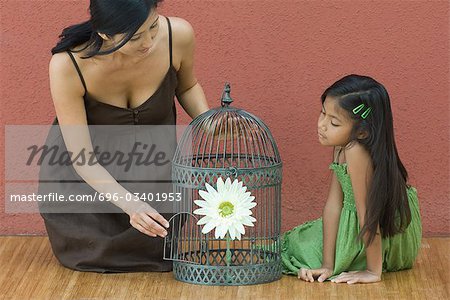 Mutter und Tochter Stock auf beiden Seiten mit Blume, Frau öffnende Tür der Vogelkäfig Vogelkäfig