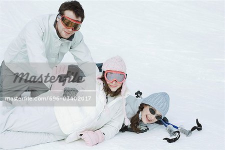 Groupe de jeunes amis playfighting dans la neige, adolescente agitant pour caméra