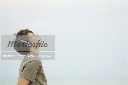 Teenager hören Kopfhörer, Blick nach oben, Seitenansicht