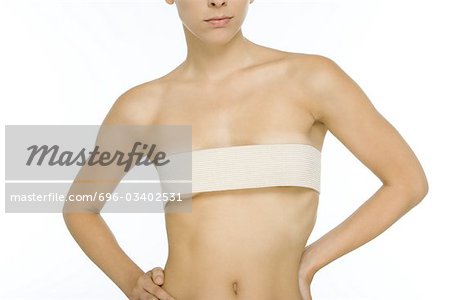 Nude woman with bandage wrapped around breasts, cropped view