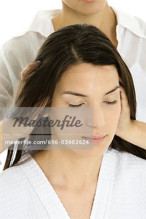 Woman receiving head massage, hands in her hair, relaxing with her eyes closed