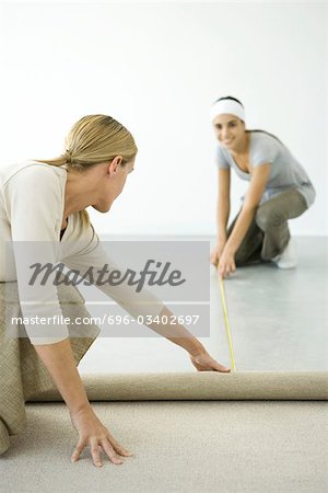 Mother and daughter installing carpet together
