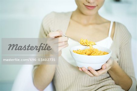 Woman holding bowl of cereal, cropped view