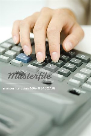 Woman's hand using adding machine, close-up