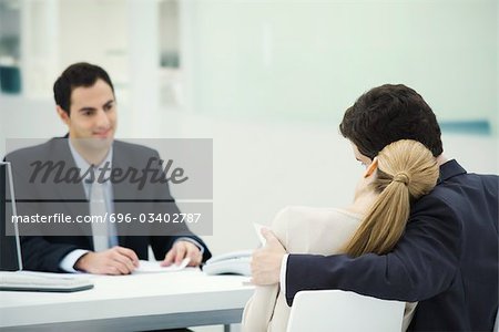Meeting between professional and clients, woman resting head on man's shoulder