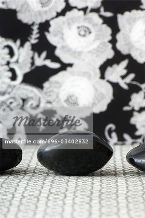 Three polished pebbles in row against patterned background, cropped