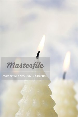 White Christmas tree shaped candles burning