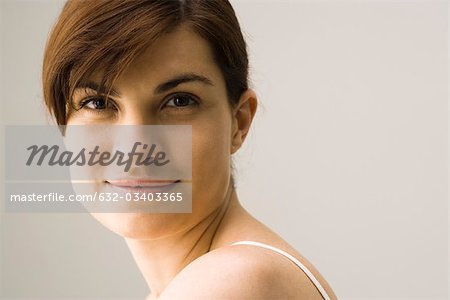 Young woman smiling over shoulder, portrait