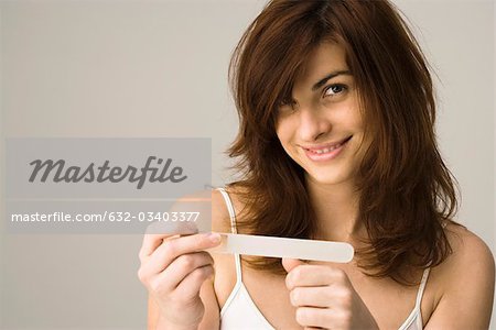 Young woman filing nails