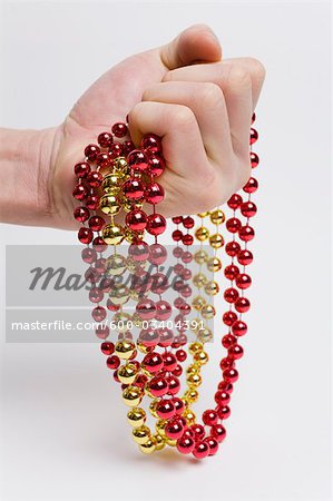 Person holding Red and Yellow Strings of Beads