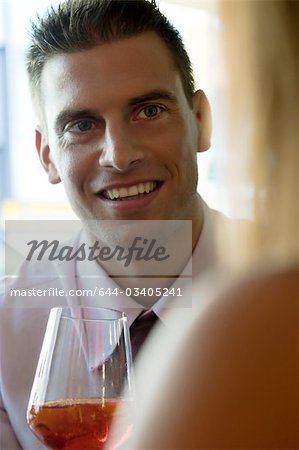 Junger Mann sitzen bei einem Glas Wein orange und junge Frau