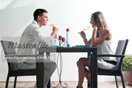 Couple sitting at table drinking white wine