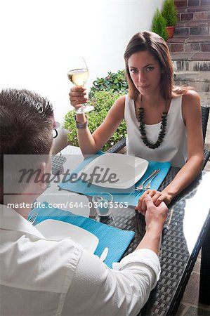 Couple sitting at table drinking white wine