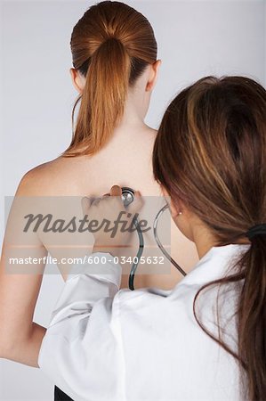 Doctor Listening to Woman's Back with Stethoscope