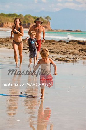 family running on beach in mexico