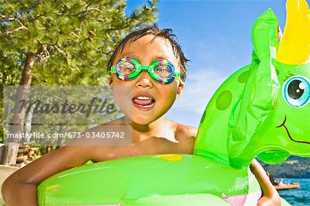 boy with dragon floatie and goggles