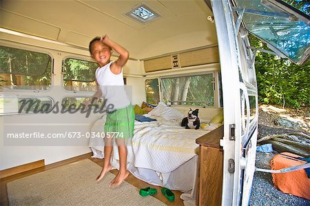 Boy and dog on bed in camper