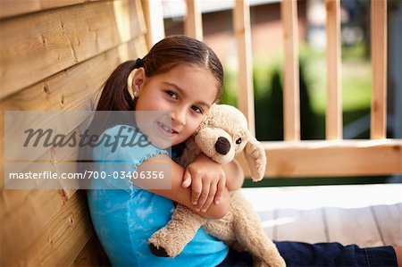 Girl Cuddling Stuffed Toy in Treehouse