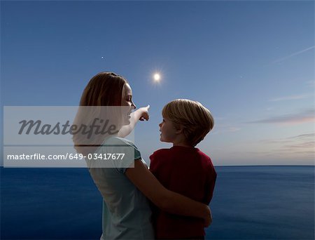 boy and girl watching the moon rising