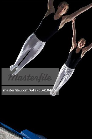 two male trampolinists mid flight