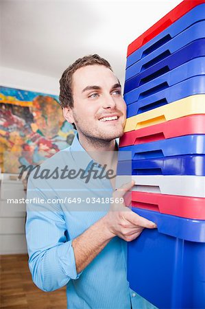 man carrying colored boxes
