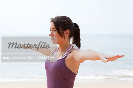 Woman practicing yoga by the sea