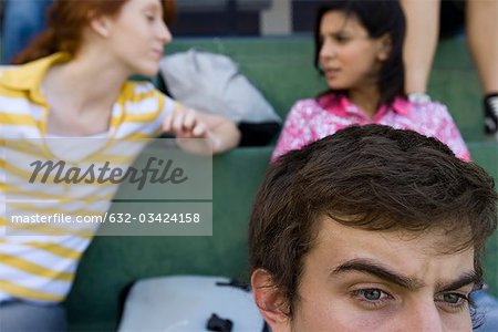 Camarades de hight assis sur les gradins, garçon en regardant attentivement, filles dans le contexte actuel