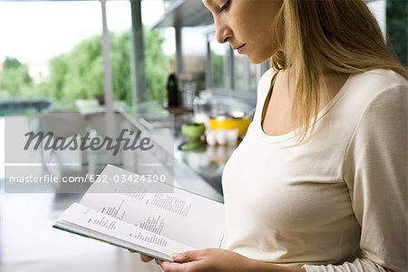 Woman reading recipe in cookbook