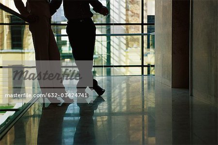 Male and female colleagues waiting for elevator