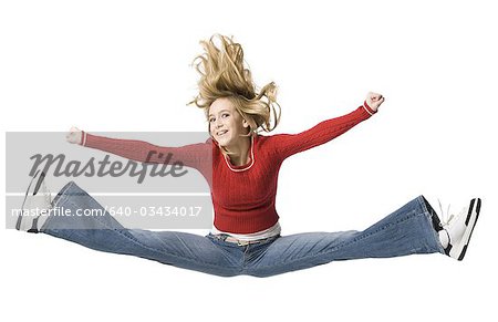 Girl with braces leaping with red sweater