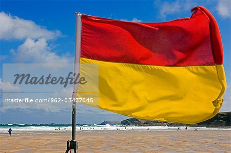 Prominantly affiche le drapeau de maîtres-nageurs sur Harlyn Bay Beach au plus fort des vacances d'été