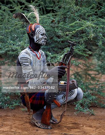 An elder of the Karo tribe,a small Omotic tribe related to the Hamar,who live along the banks of the Omo River in southwestern Ethiopia. The Karo are renowned for their elaborate body painting using white chalk,crushed rock and other natural pigments. This man also has a clay hairdo typical of tribal elders. Like most adult males he carries a rifle.