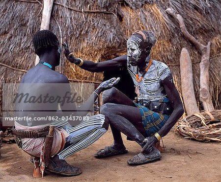 Karo men paint each other in preparation for a dance in the village of Duss. A small Omotic tribe related to the Hamar,who live along the banks of the Omo River in southwestern Ethiopia,the Karo are renowned for their elaborate body painting using white chalk,crushed rock and other natural pigments.