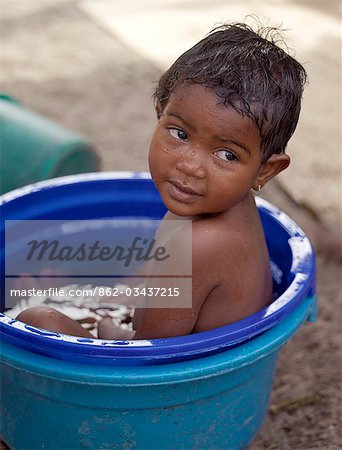 Ein junges Mädchen der madagassischen nimmt ein Bad in einer großen Plastikschüssel in den Fischen Dorf von Ramena nahe Antsiranana (ehemals Diego Suarez).