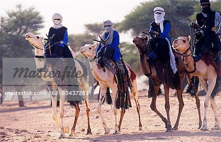 Niger, Oasis de Timia. Coureurs de Touaregs se préparent à leurs chameaux de course dans le cadre du Festival de la moisson du printemps.