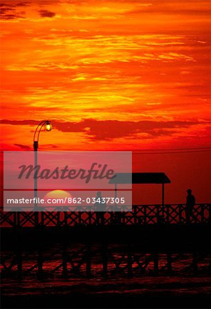 The sun sets over the Pacific,silhouetting the jetty at Huanchaco on the north coast of Peru