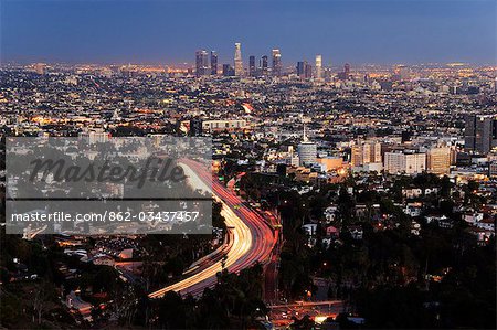 États-Unis, Californie, Los Angeles. Gratte-ciels du centre-ville et des lampes de voiture sur une route de la ville.