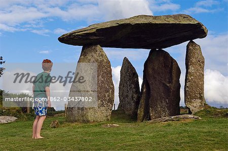UK,Wales,Pembrokeshire. A young boy visits the site of the ancient neolithic dolmen at Pentre Ifan,Wales's most famous megalith,the remains of a vast Celtic burial mound,.