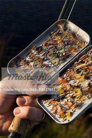 Au Royaume-Uni, pays de Galles, Conwy. Un pêcheur sélectionne une mouche dans sa boîte à mouche et pêche à la truite au pays de Galles