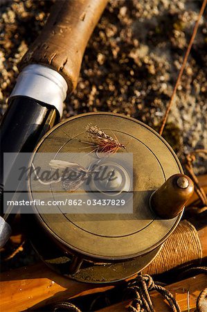 UK,Wales,Conwy. A traditional brass fishing reel fitted to a split-cane fly rod with trout fishing flies