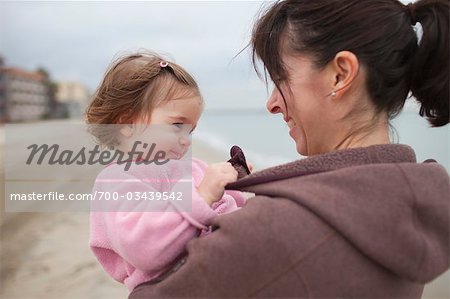 Nahaufnahme der Mutter Holding junge Tochter in den Armen, Long Beach, Kalifornien, USA
